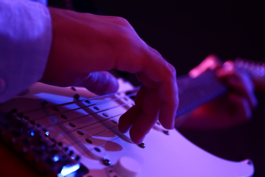 Learn to Play Music Man playing guitar, closeup view